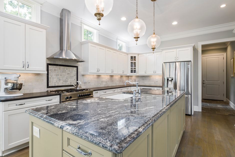 Spacious kitchen featuring sleek granite countertops, stainless steel appliances, and elegant lighting.